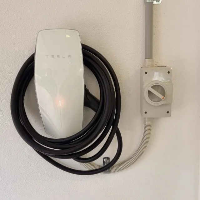 Tesla wall charger installed by JR Dixon Electrical with neatly coiled charging cable